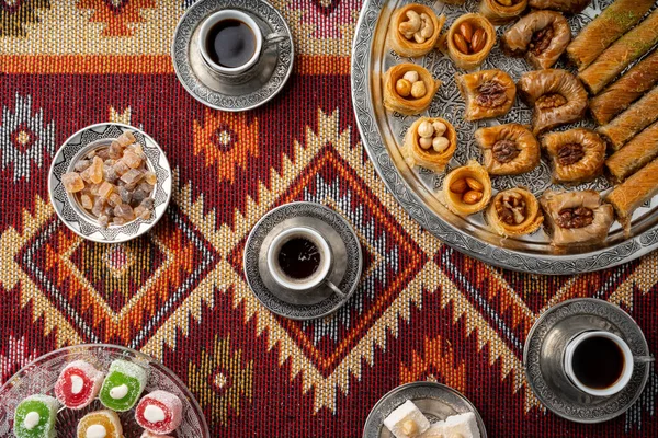 Café turco y dulces servidos en alfombra estampada de colores — Foto de Stock