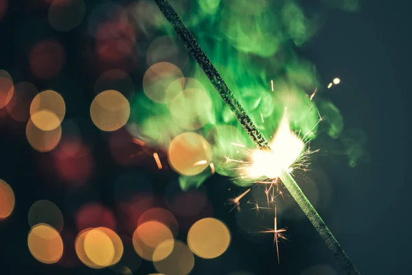 Close-up of green holiday sparkler in the dark — Stock Photo, Image