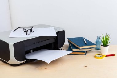 Ofis yazıcısı ahşap bir masaya yakın.