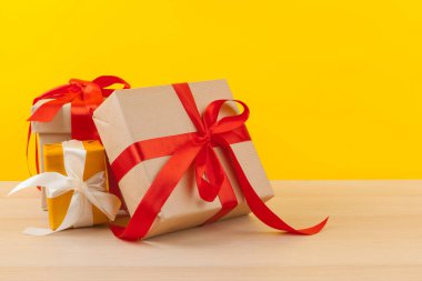 Parlak sarı arkaplanda kurdeleli hediyeler