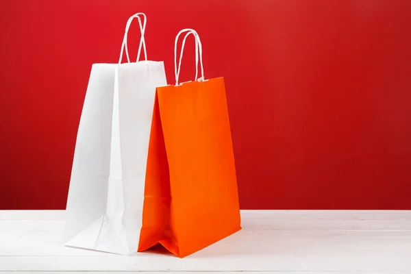 赤い背景にコピースペースのある紙のショッピングバッグ — ストック写真