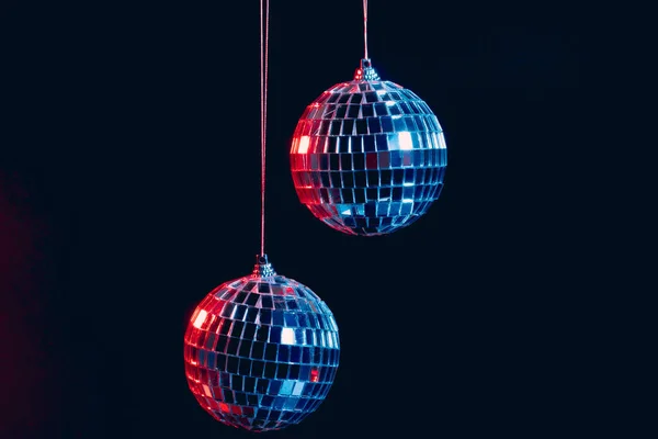 Bolas de discoteca espumantes penduradas no ar contra fundo preto — Fotografia de Stock