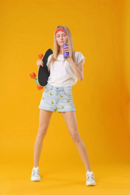 Stüdyoda kaykayla poz veren güzel ve moda ergeni.