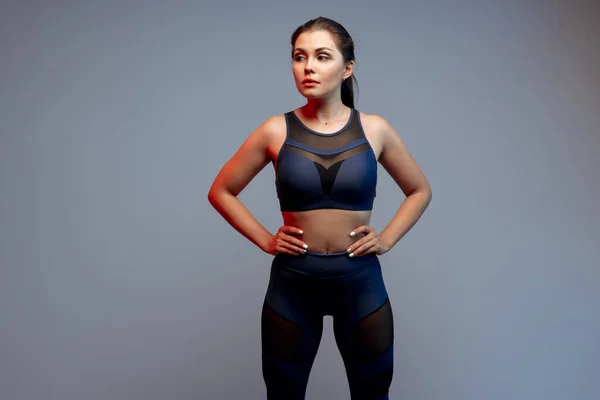 健康フィット若いです女性でスポーツウェアスタンディング上の灰色の背景 — ストック写真