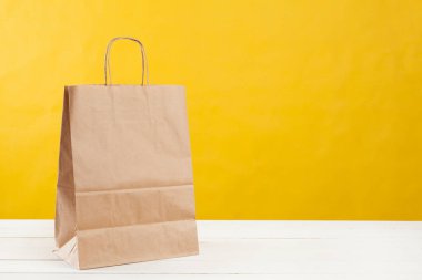 Parlak sarı arka planda alışveriş torbaları düzenleme