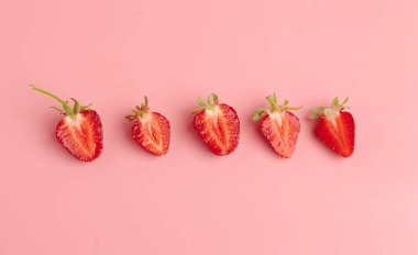 Pembe arka planda çilekler. Taze organik gıda konsepti