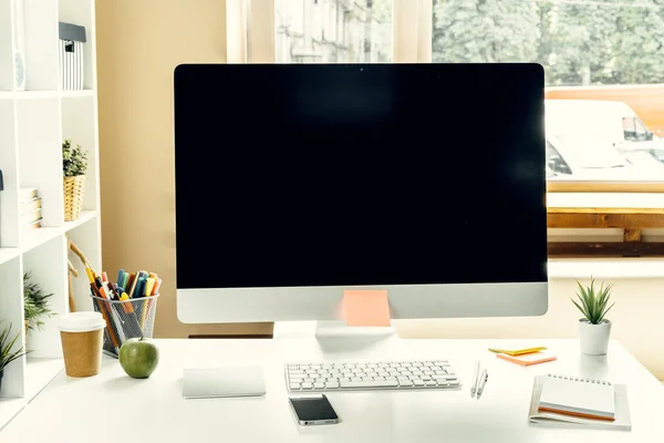 Kantoor- of thuiswerkruimte. Computer monitor met zwart scherm op kantoor tafel met benodigdheden — Stockfoto