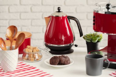 Mutfak rafında kırmızı çatal bıçak ve bulaşık takımı var.