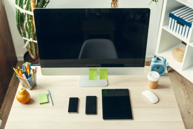 Ofis ya da ev işi. Ofis masasında malzemelerle siyah ekranlı bilgisayar monitörü