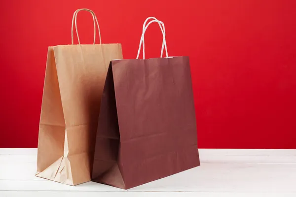 Varias bolsas de compras con espacio de copia sobre fondo rojo —  Fotos de Stock