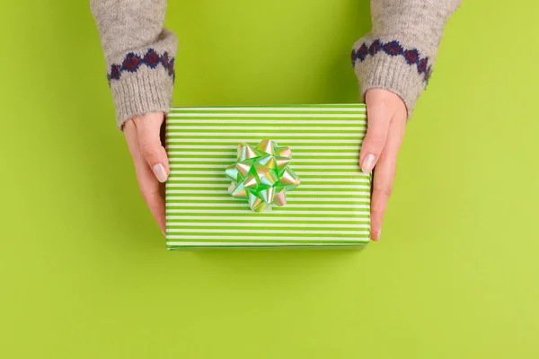 Γυναίκα χέρια κρατώντας κουτί δώρου σε πράσινο φόντο — Φωτογραφία Αρχείου