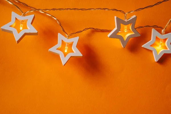 Guirnalda iluminada en forma de estrella sobre fondo de color de cerca —  Fotos de Stock