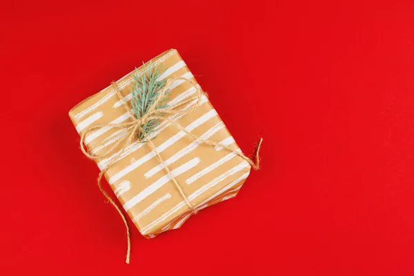 Insvept presentförpackning på en röd bakgrund, vy ovanifrån — Stockfoto