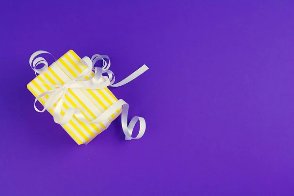 Geschenkdoos op paarse achtergrond bovenaanzicht — Stockfoto