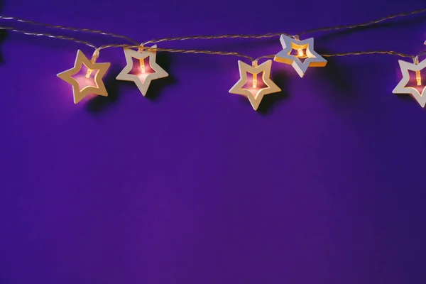 Verlichte ster vormige slinger op kleur achtergrond close-up — Stockfoto
