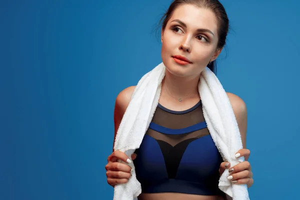 Trevlig ung kvinna i sport kläder håller en handduk i gymmet — Stockfoto