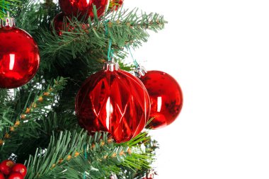 Beyaz zemin üzerinde kırmızı takılar bulunan ladin dalları