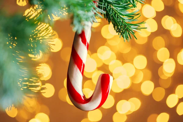 Decoración de Navidad colgando de una rama de abeto contra las luces de Navidad — Foto de Stock