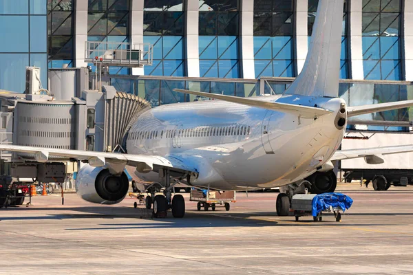 L'avion est stationné près de la porte d'embarquement de l'aéroport — Photo