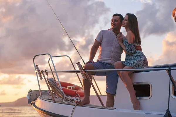 Beau couple regardant le coucher du soleil depuis le yacht — Photo
