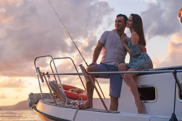 Beautiful couple looking at sunset from the yacht — Stock Photo, Image