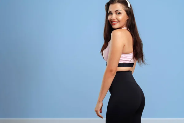 Porträtt av en ung fitness kvinna i sportkläder poserar i studio — Stockfoto
