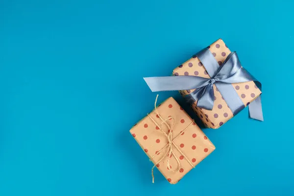 蓝色背景上装饰有蝴蝶结的礼品盒平铺 — 图库照片
