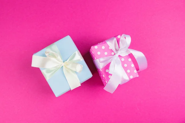 Vista dall'alto di un regalo decorato con fiocco su sfondo rosa — Foto Stock