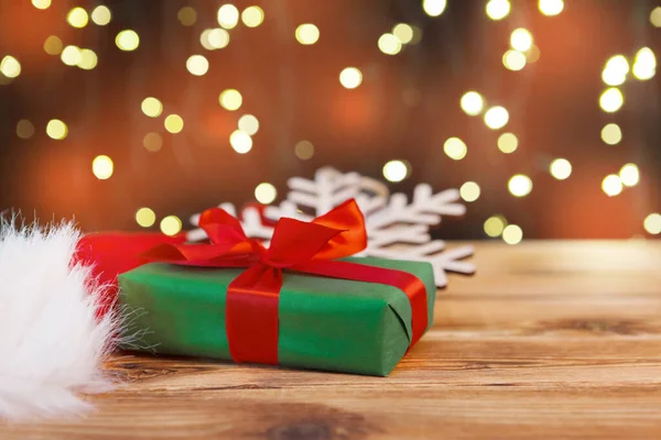 Tarjeta de felicitación navideña con cajas de regalo contra fondo de luces borrosas —  Fotos de Stock