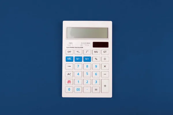 Horní pohled na kalkulačku na klasickém modrém pozadí — Stock fotografie