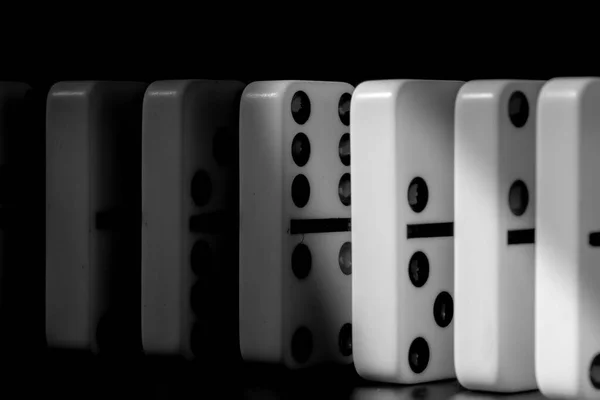 Domino pieces put in a row on black background — Stock Photo, Image