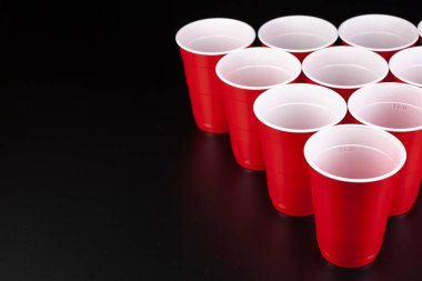 Bira pong oyunu için kırmızı plastik bardakların düzenlenmesi