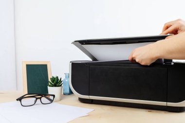 Kopyalama makinesi kullanan bir kadının elleri.