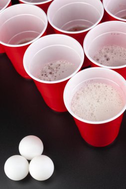 Bira pong oyunu için kırmızı plastik bardakların düzenlenmesi