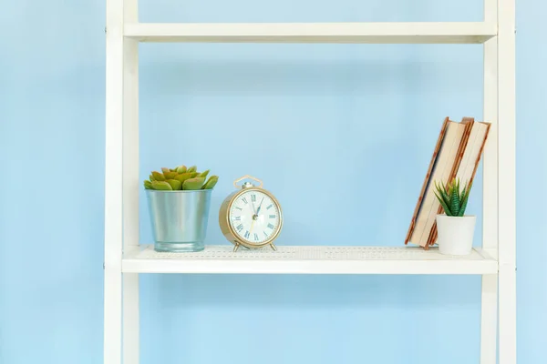 Support en métal blanc avec livres sur fond bleu — Photo