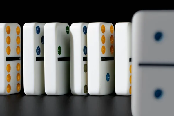 Domino 's staan in een rij op zwarte achtergrond — Stockfoto
