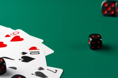 Zarlar ve kartlar masaya saçılmış.