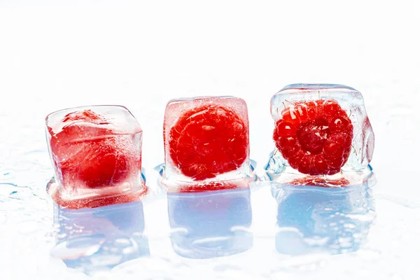Las bayas congeladas en los cubos de hielo sobre rosado —  Fotos de Stock