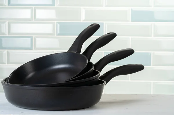 Clean and dry cooking pans on a kitchen counter