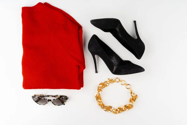 Kobiecy strój z czerwonym swetrem i dodatkami na białym — Zdjęcie stockowe