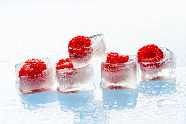 Cubos de hielo con bayas congeladas dentro de cerca —  Fotos de Stock