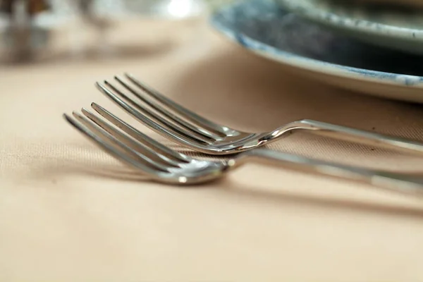 Masanın üstünde masa örtüsü olan gümüş çatal bıçak takımı. — Stok fotoğraf