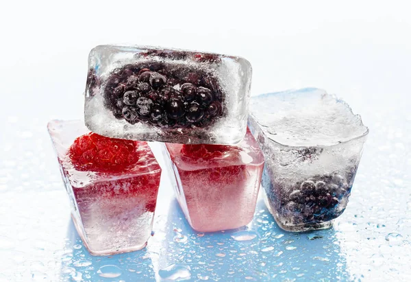Кубики льоду з замороженими ягодами всередині крупним планом — стокове фото