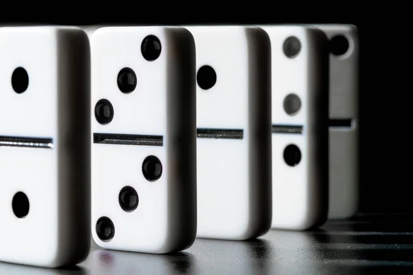 Domino stojące w rzędzie na czarnym tle — Zdjęcie stockowe