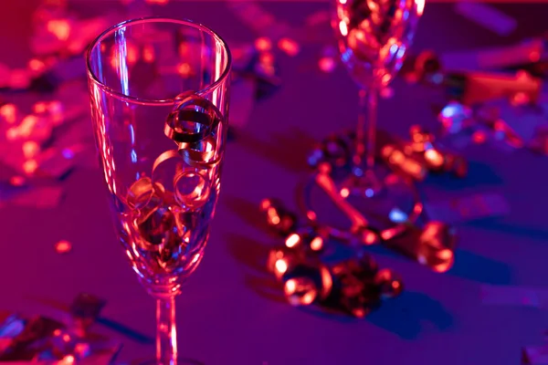 Copas de champán con oropel de fiesta sobre fondo brillante — Foto de Stock