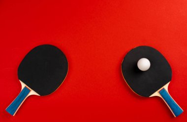 Kırmızı arkaplanda siyah ping pong raketleri