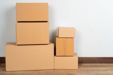 Tahta zeminde kahverengi karton kutular var.
