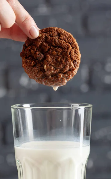 Жіноча рука стукає печиво в молоці крупним планом — стокове фото