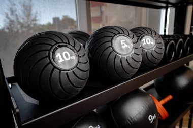 Spor salonunda toplar ve köpüklü tekerlekli spor aletleri.