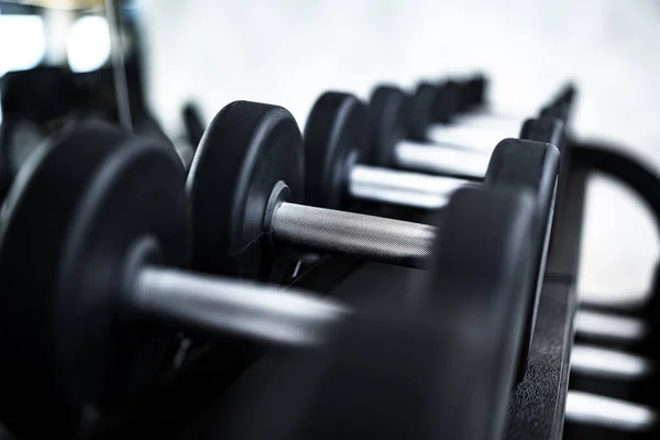 Close up of new dumbbells on a rack in a gym — Stock Photo, Image
